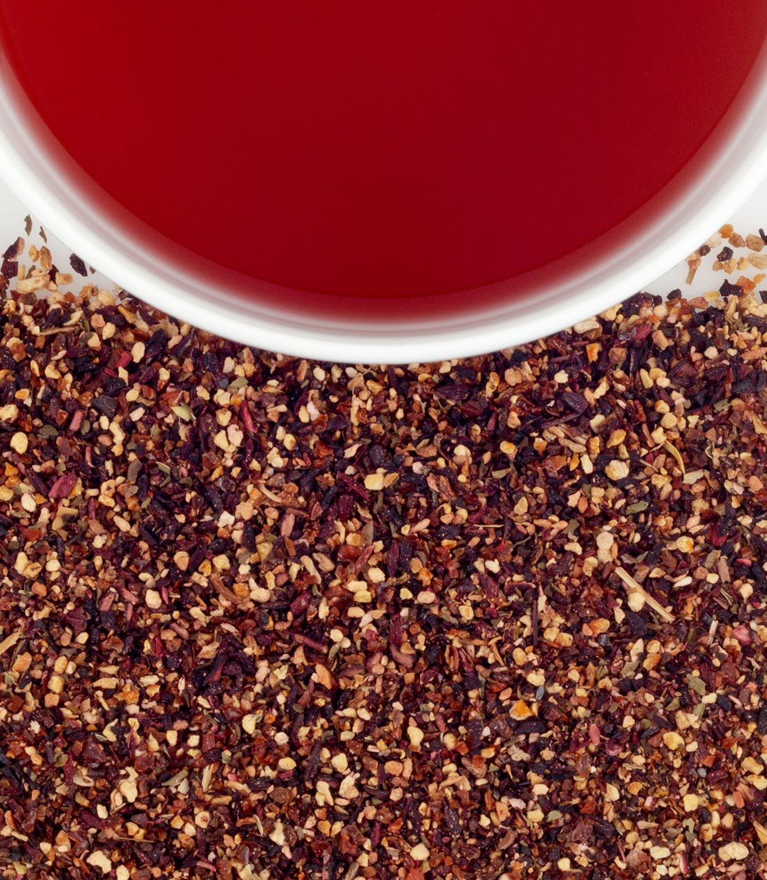 Harney & Sons Raspberry Herbal tea brewed liquor alongside loose dry herbal tea leaves